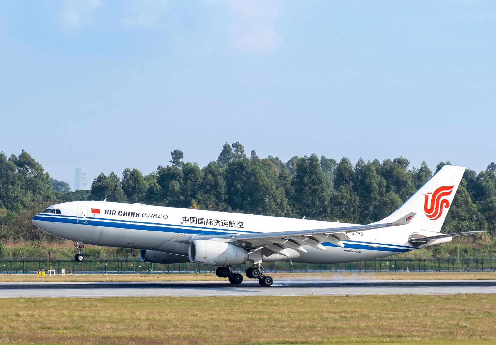 Cargo aircraft lifting off from a runway against a clear blue sky.