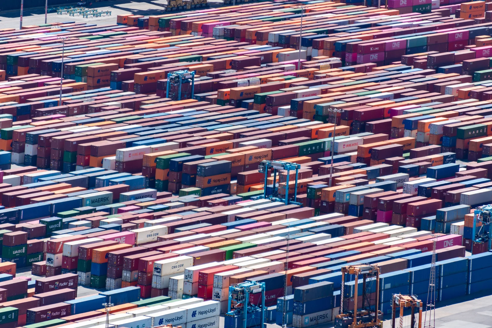 Rows of colourful shipping containers stacked across a freight terminal.